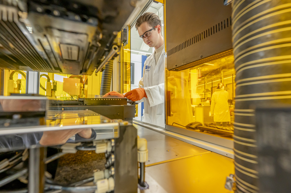 Researcher in white lab coat and safety goggles preparing the multi printheads inkjet 3D print system Toucan to print a multimaterial part