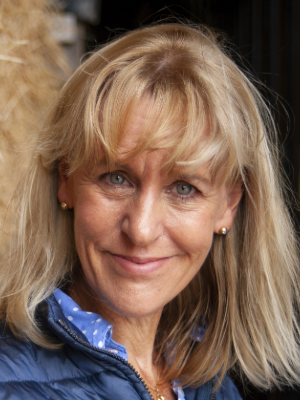 Headshot of Minette Batters with a brown background