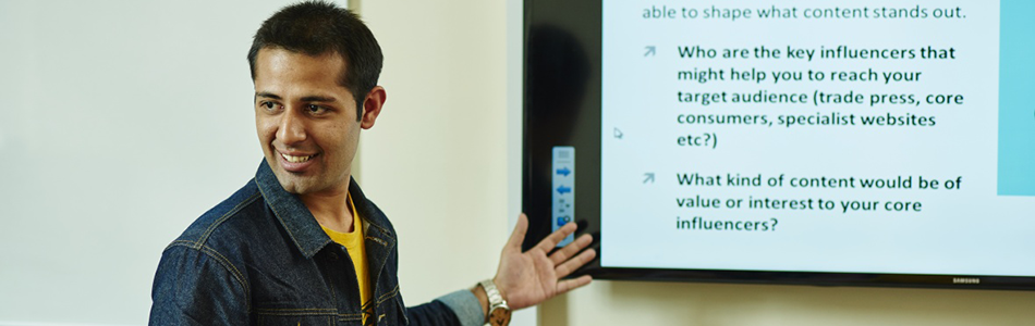 Student giving a presentation in front of a display screen