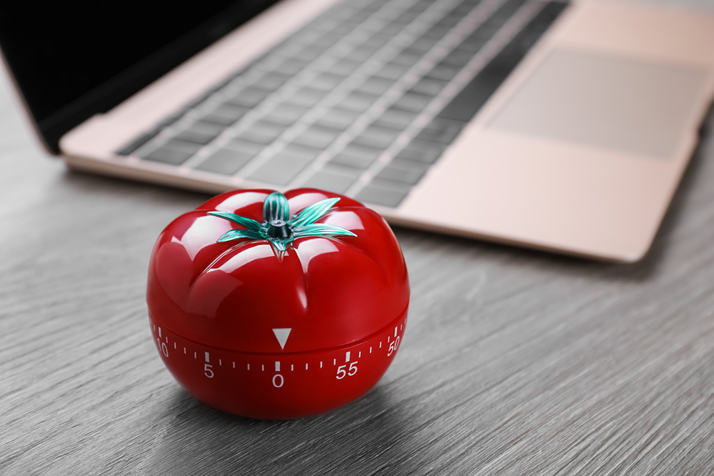 Tomato timer next to a laptop