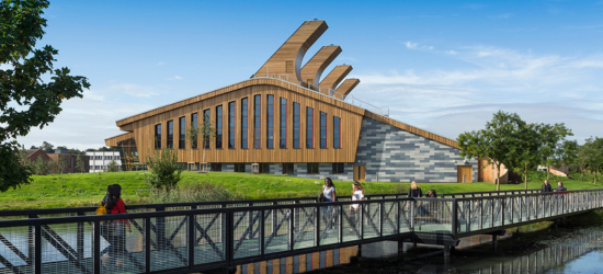 Photo of people walking over a bridge on Jubilee Campus with the Carbon Neutral Building in the background.